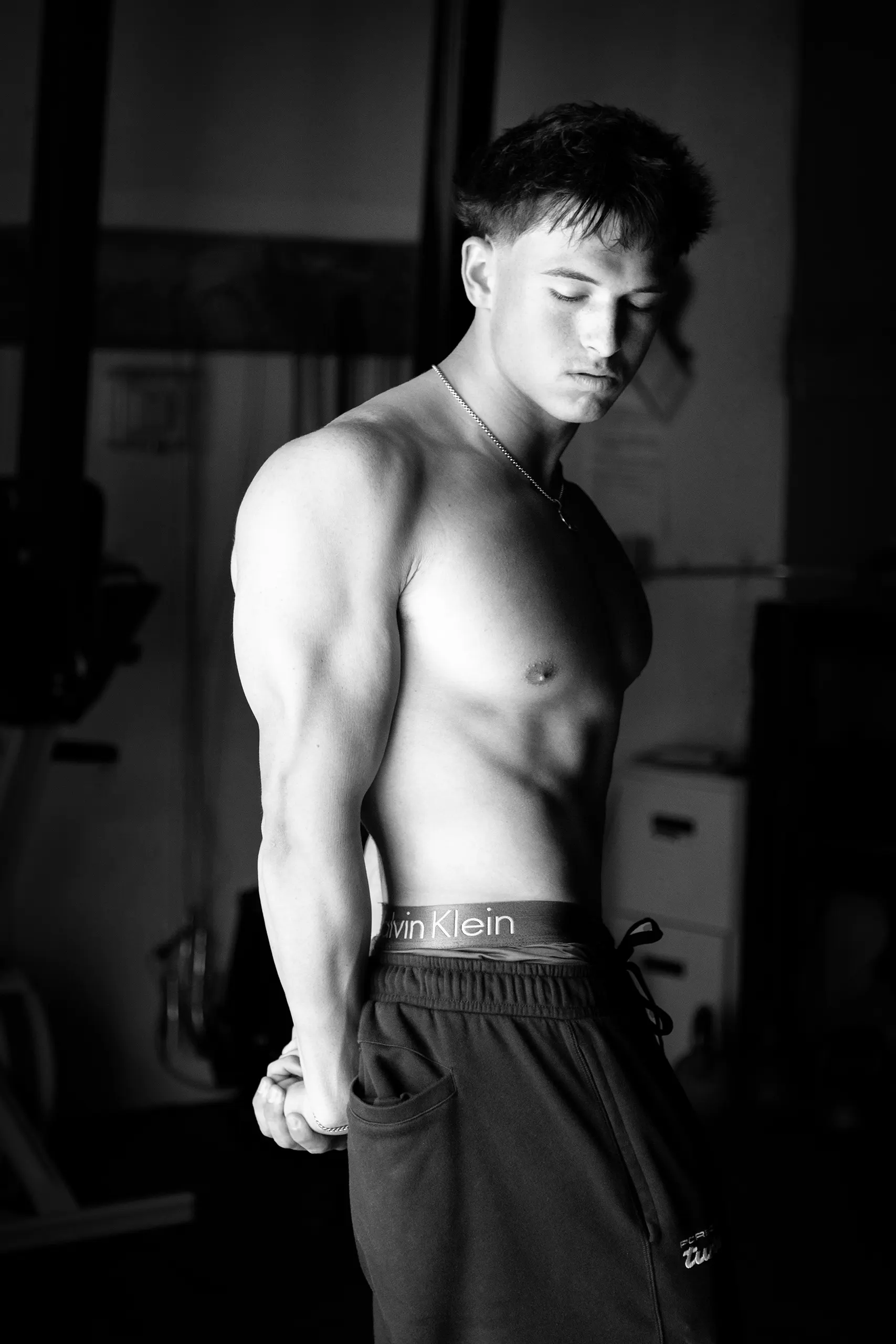 Male high school senior photo in gym, black and white portrait