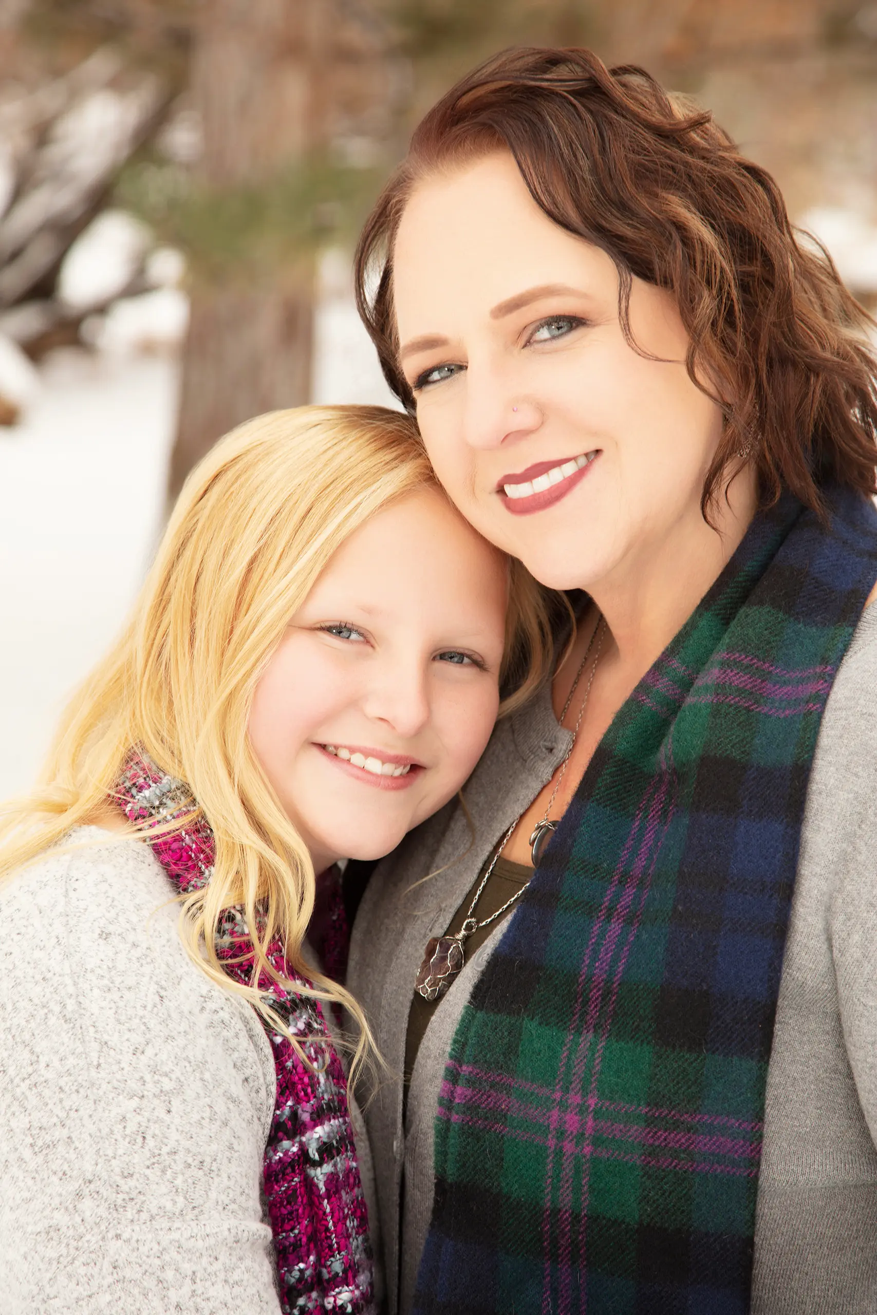 A heartwarming close-up portrait of a mother and her young daughter showing genuine connection during a family session.