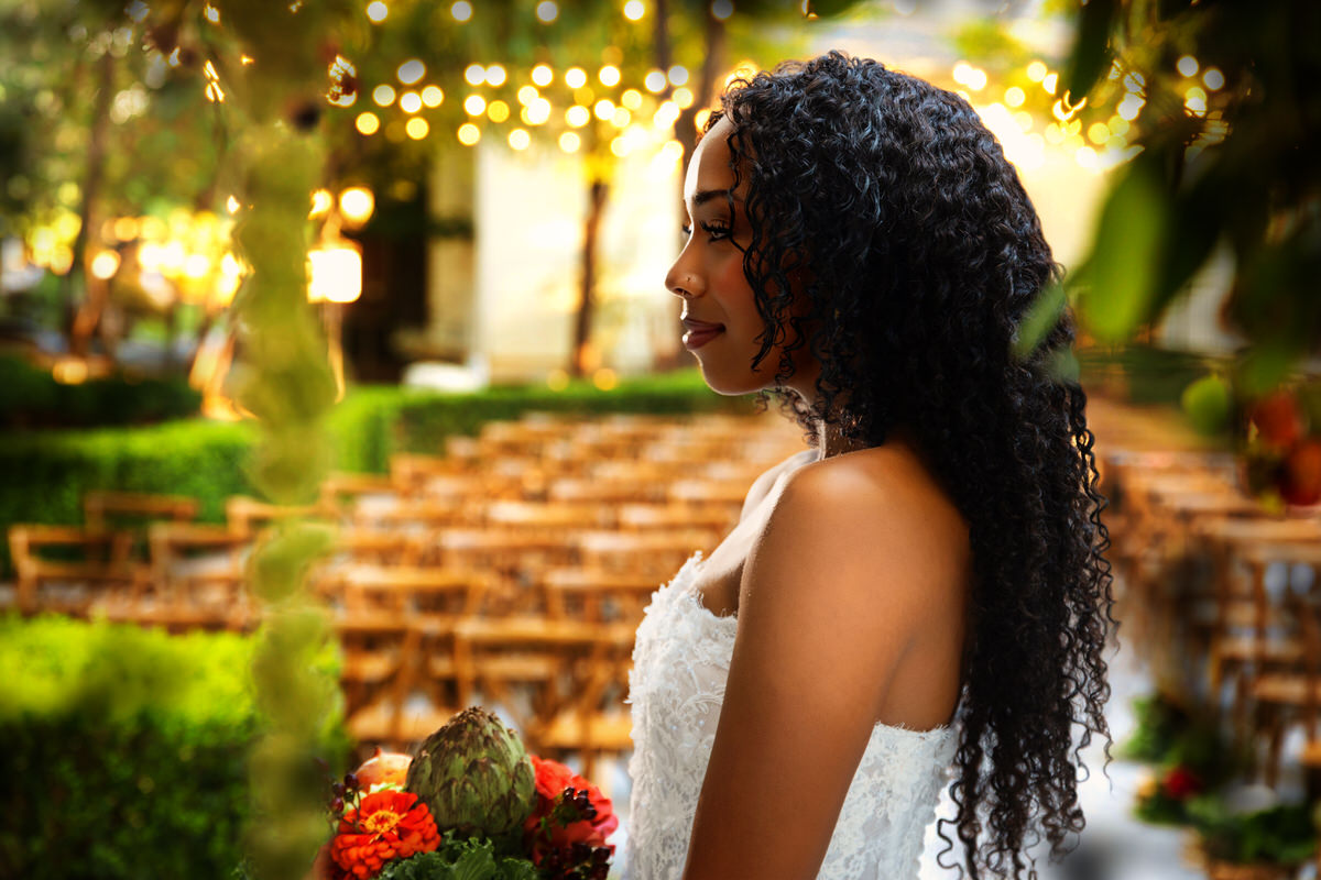 Profile portrait of a bride looking thoughtfully off to the side, wearing a strapless lace gown from Just Girl Stuff during a bridal photo shoot by Masterpiece Images in Ogden, Utah.
