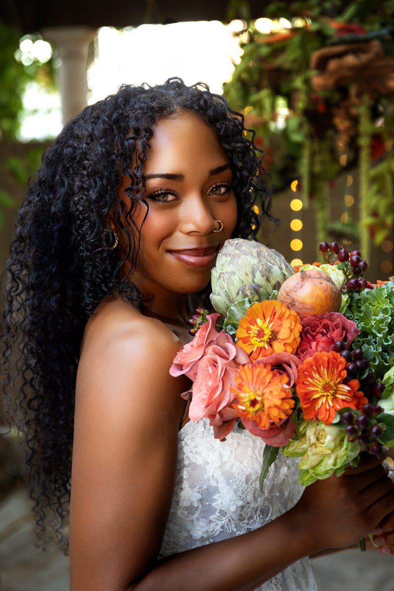 Close-up portrait of a radiant bride smiling during a styled photo shoot by Masterpiece Images, featuring floral arrangements by Lund Floral in Ogden, Utah.