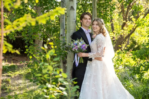 Bride holding colorful summer wedding floral bouquet outdoors