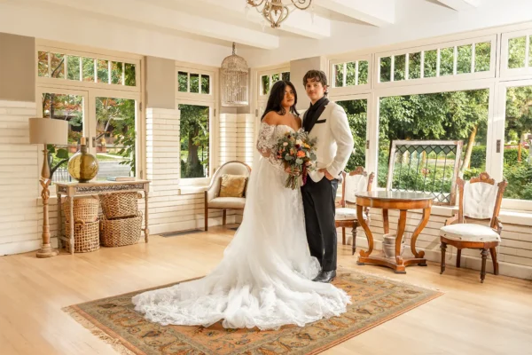 Bride and groom standing together indoors with a floral bouquet in Ogden Utah
